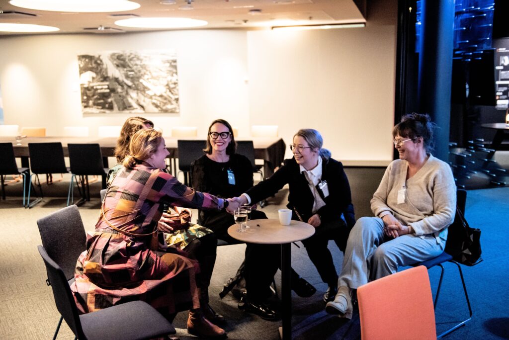 Alumner och ambassadörer hälsar på varandra.